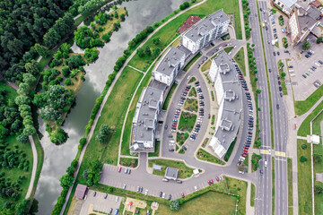 Wall Mural - city apartment complex on riverbank. aerial view in cloudy summer day. drone photography.