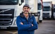 Happy and smiling truck driver portrait in front of trucks