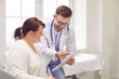 © Studio Romantic - Male doctor consulting overweight woman in medical office. Smiling chubby, plus size young woman visiting nutritionist, therapist, general practitioner in clinic