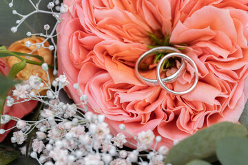 Wall Mural - Beautiful wedding rings close-up macro photography. Bride and groom's wedding rings  beautiful flowers