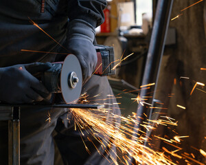 Wall Mural - The man holds a flexi in his hands and cuts a metal plate