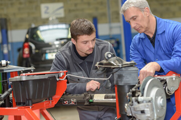 teacher and student in auto mechanics training class