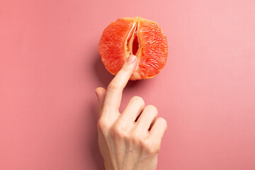  A woman is holding a grapefruit by her panties. Concept masturbation