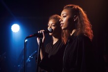 Shot Of A Two Young Female Singers On Stage With Their Band