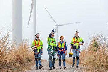 Teamwork engineer worker wearing safety uniform discuss operational planning at wind turbine field renewable energy. technology protect environment reduce global warming problems.