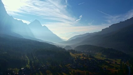 Wall Mural - Aerial view of the morning sun behind the mountains, Dolomites Cortina d'Ampezzo