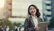 © TeteraX - Asian business woman leader entrepreneur, standing on the street in a big city against sky background with replica space. Generated by AI
