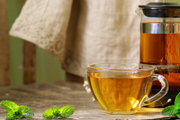 Poster - tea in a cup and french press on a wooden table