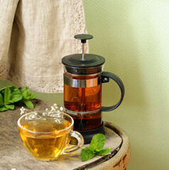 Poster - tea in a cup and french press on a wooden table