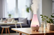 Humidifier on a table in a living room at home blurred background. White plastic humidifier with white steam jet in cozy interior design, commercial photo for catalog.
