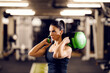 © Dusan Petkovic - A strong female bodybuilder is doing exercises with heavy weights on her shoulders in a gm.