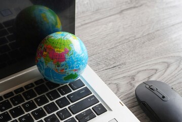 Wall Mural - Close up image of globe, laptop keyboard and computer mouse. Internet, globalization and technology concept