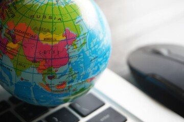 Wall Mural - Close up image of globe, laptop keyboard and computer mouse. Internet, globalization and technology concept