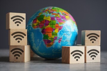 Wall Mural - Closeup image of globe and wooden cubes with wifi icon. Internet and global network concept