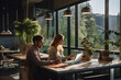 © Maksym - The man and woman working on their laptops at a shared workspace with a view