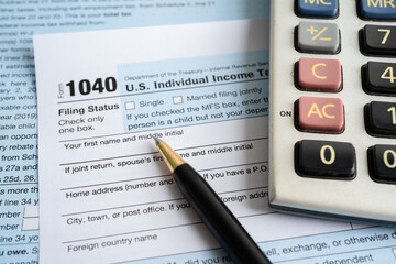 Wall Mural - Tax Return form Individual Income with calculator and pen.