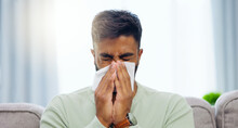 Tissue, Sneeze And Indian Man Blowing Nose On A Home Living Room Sofa Feeling Sick And Tired. Allergy Problem, Virus And Toilet Paper Of A Person On A House Lounge Couch With Sinus Infection And Flu