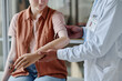 © Seventyfour - Close up of doctor fitting prosthetic arm to young woman in orthology clinic, copy space
