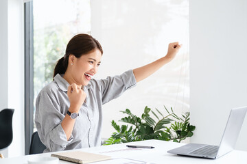 Poster - Beautiful Asian girl celebrate with laptop, success happy pose. E-commerce, university education, internet technology, or startup small business concept. Modern office or living room with copy space