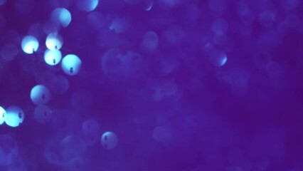Wall Mural - Blue Bokeh Motion On Purple Background. Abstract movement of blurry circles with light spots. Amazing dreamslike backdrop.