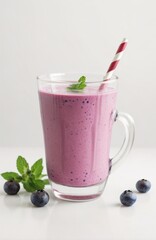 Wall Mural - Blueberry smoothie or milkshake in a glass with straw, fresh berries and mint. Summer refreshing drink 