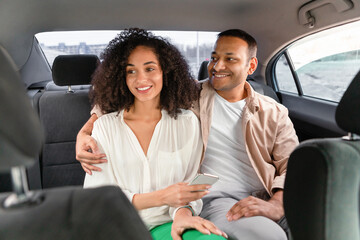 Smiling Arab Passengers Couple Enjoying Comfortable Car Ride In Taxi