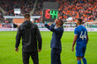 Man shows players substitution during football match.