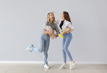 Canvas Print - Young women with wallpaper rolls near grey wall