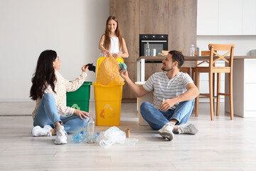 Wall Mural - Family sorting garbage with recycle bins in kitchen