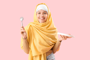 Canvas Print - Beautiful Arabian woman with empty plate and spoon on pink background