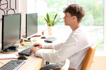 Canvas Print - Male programmer working with computer at table in office