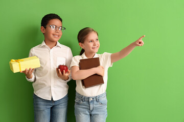 Sticker - Little students with book, gift and apple on green background