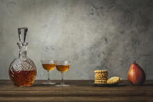 Sherry In Vintage Glasses And Decanter With Stack Of Cookies And A Pear
