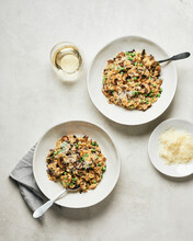 Two Bowls Of Mushroom Risotto With Peas And White Wine