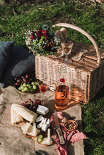 Winter Picnic Scene With Basket, Flowers And Grapes And Cheese