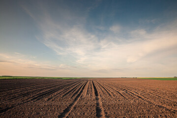 selective blur on furrows on a agricultural landscape near a farm, a plowed field in the countryside