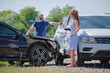 © bilanol - Angry woman and man drivers of heavily damaged vehicles arguing who is guilty in car crash accident on street side. Road safety and insurance concept