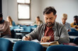 © Drazen - Mature man studying while attending adult education training class in classroom.