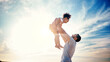 © Ramba/peopleimages.com - Father lifting kid, air and blue sky with family, travel and freedom outdoor, bonding and ocean with girl and man. Happy people, sunshine and tropical vacation, child flying with dad and adventure