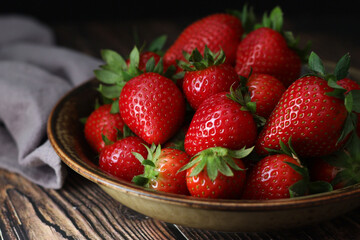 Wall Mural - A bowl with ripe bright strawberry in rustic style