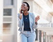 © Tshidzumba/peopleimages.com - Business, walking and phone call of happy woman in city for conversation, mobile networking and funny communication. African worker talking on smartphone for contact, chat and laugh in urban street