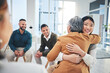 © Azee/peopleimages.com - Business people, women and hug in group therapy with care, love and bonding for mental health in workplace. Corporate men, staff and colleagues with smile for team building, diversity and gratitude