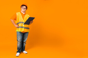 Wall Mural - Smiling young man with down syndrome in glasses in work uniform with cash register on head, place for text