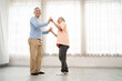 © artitwpd - Romantic and cheerful Asian well-being senior couple enjoy dancing and holding hands to music together with smiles and happiness in the living room. Senior retirement activity at home.