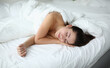 © H_Ko - Beautiful woman sleep and smile with her hand under her cheek. Sell white and soft bedding from best fabric.