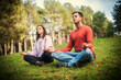 © guruXOX - Young couple in everyday casual clothing doing yoga relax exercise in nature park outdoor