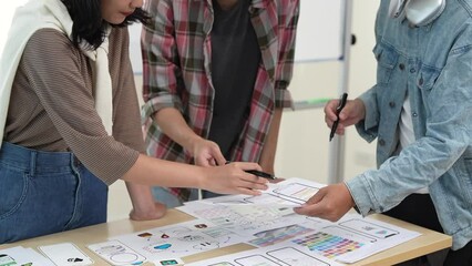 Young Asian business creative developer team work design. Creative UI Ux designer meeting planning designing wireframe layout application development for smartphone screen mobile phone technology