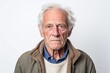 © Leon Waltz - Medium shot portrait photography of a man in his 60s with a pained and tired expression due to fibromyalgia wearing a chic cardigan against a white background