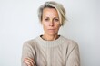 © Leon Waltz - Lifestyle portrait photography of a woman in her 40s showing tiredness and a worn-down expression due to chronic fatigue syndrome wearing a cozy sweater against a white background