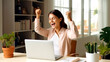 © Ketanoff - Excited happy business young woman sitting with laptop  raising hands up and celebrating success, female feeling winner rejoicing online win. Generated with AI